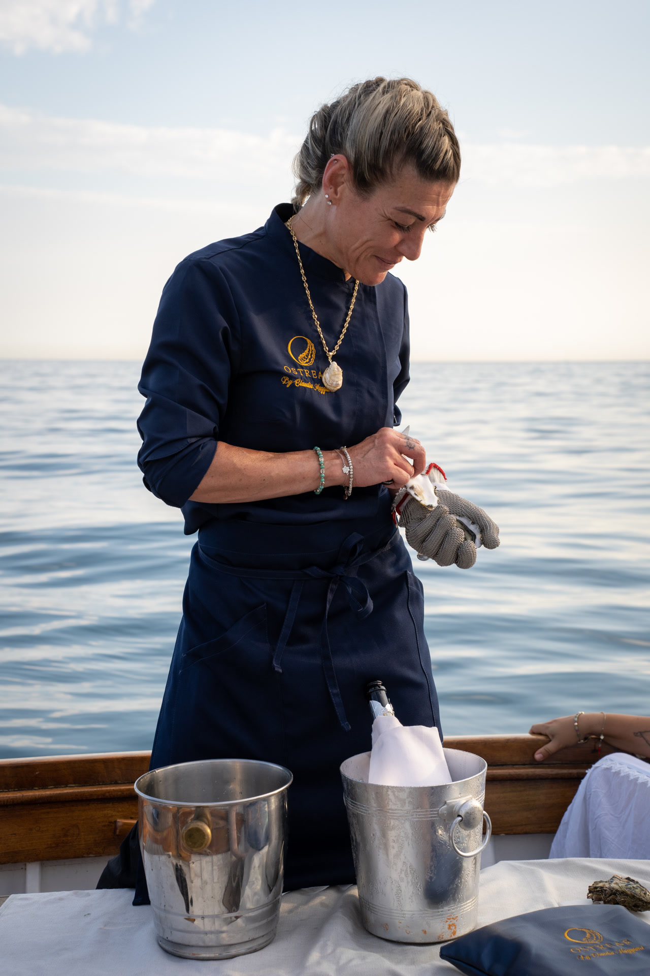 Claudia Maggiani in divisa Ostreae su una barca, al lavoro con le ostriche