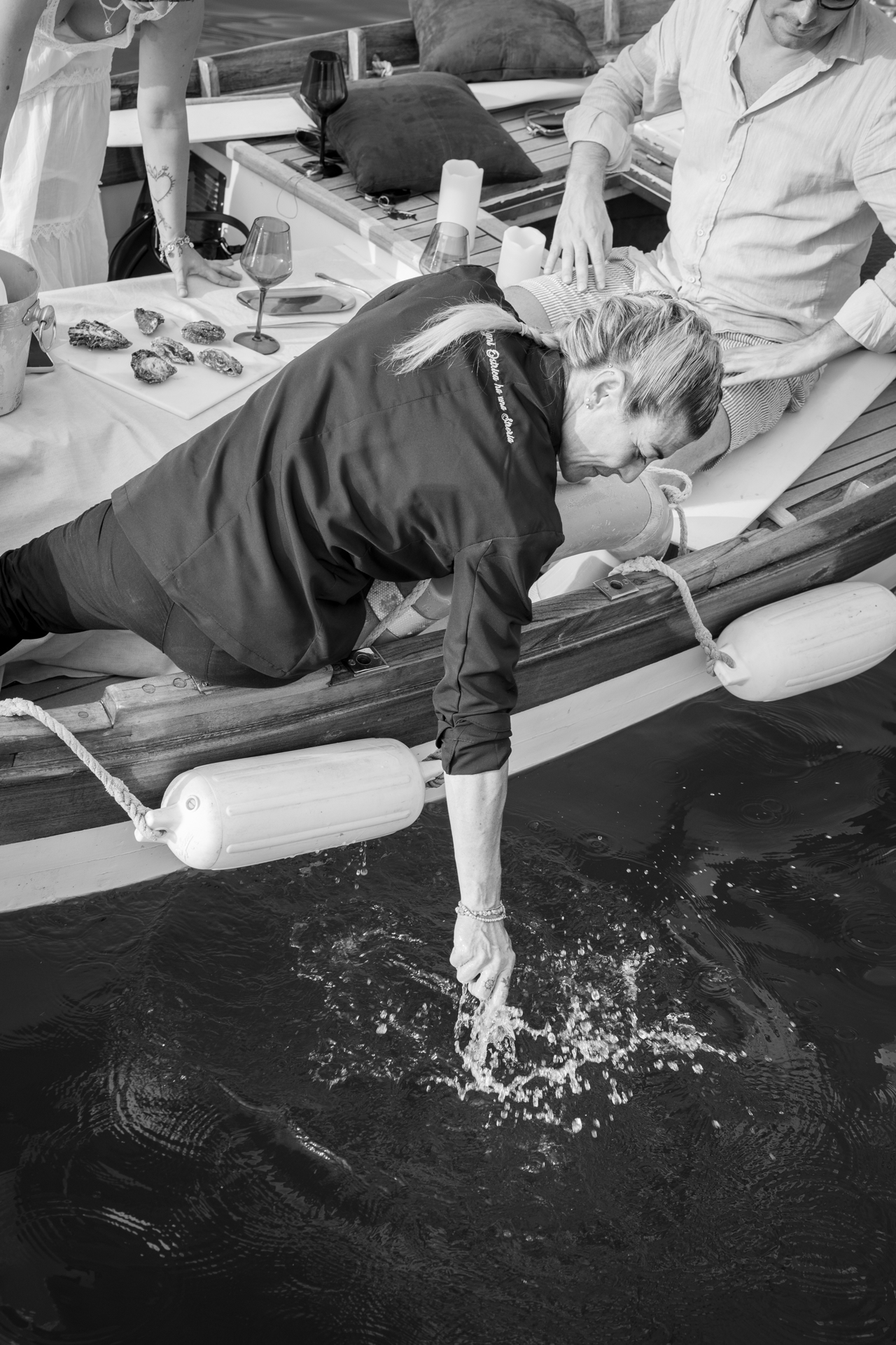 Claudia Maggiani immerge la mano nel mare dalla barca